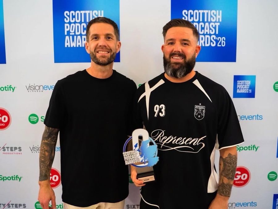 Greg and his co-host holding a Scottish Podcast Awards trophy